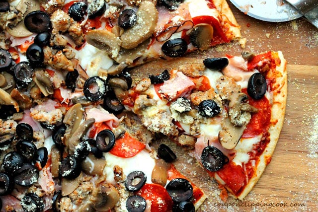 Boboli Bread Pizza with Sausage, Ham, Mushrooms and Pepperoni on board