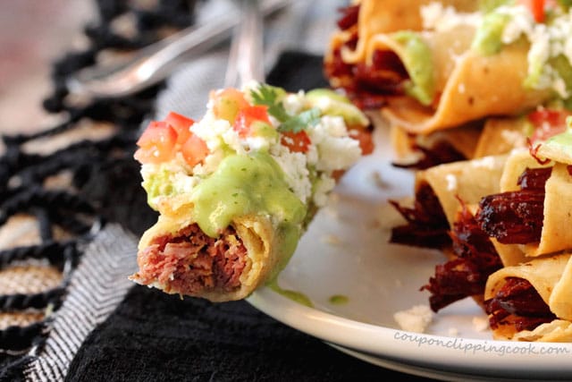 Bite of Corned Beef Taquitos with Avocado Sauce on plate