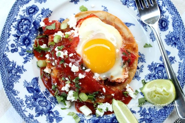 Huevos Rancheros (egg tostada) on plate with lime