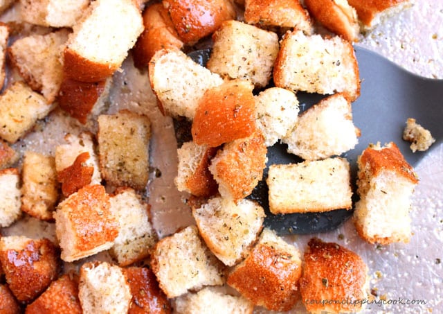 Cut bread for croutons on pan